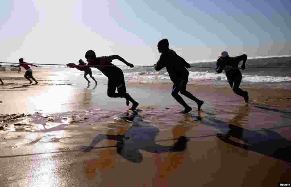 Fishermen pull in nets during the annual sardine run, in Winklespruit, near Durban, South Africa.