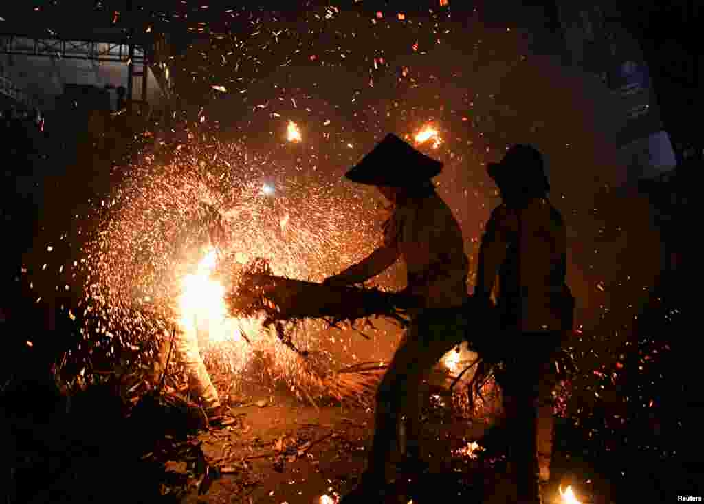 Youths play with sparks and flames from coconuts and banana leaves during a torch battle following an annual traditional event to express gratitude for the harvest and reject reinforcements, in Tahunan Village, Jepara, Central Java province, Indonesia, June 20, 2022.