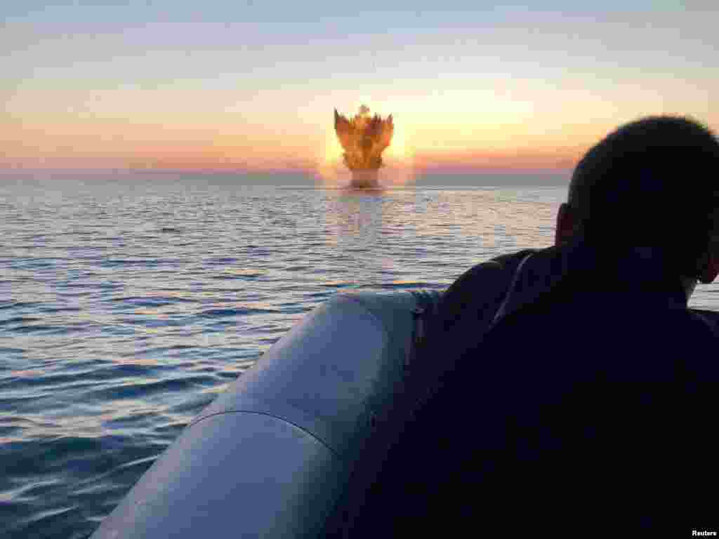 Bulgarian navy personnel destroy a naval mine in the Black Sea, Bulgaria, in this handout image.