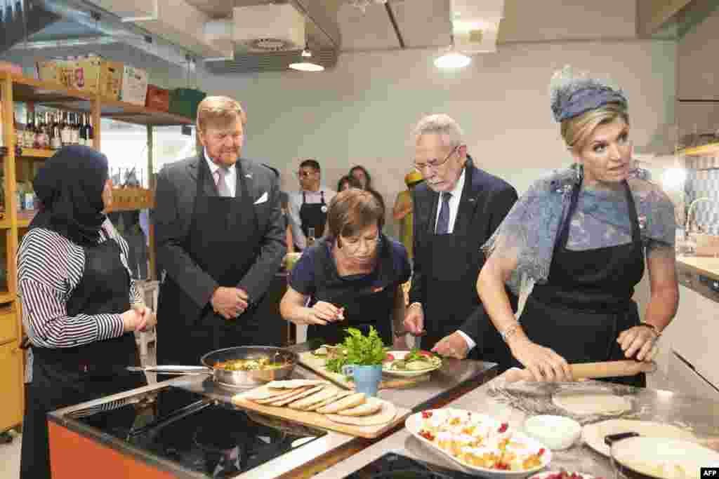 King Willem-Alexander of the Netherlands (2nd L) and Queen Maxima of the Netherlands (R), together with Austrian President Alexander Van der Bellen (2nd R) and his wife Doris Schmidauer (C), visit the "Community Cooking" project of Caritas in Vienna, Austria.