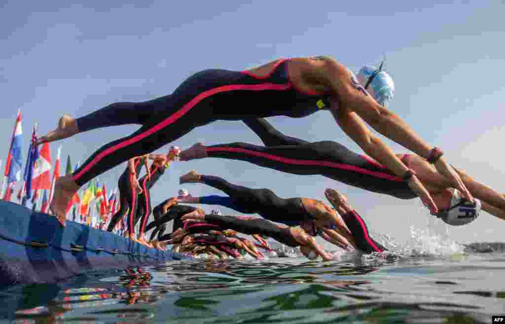 Swimmers take the start of the women's 10-kilometer open water swim event during the Budapest 2022 World Aquatics Championships at Lake Lupa in Budapest, Hungary.