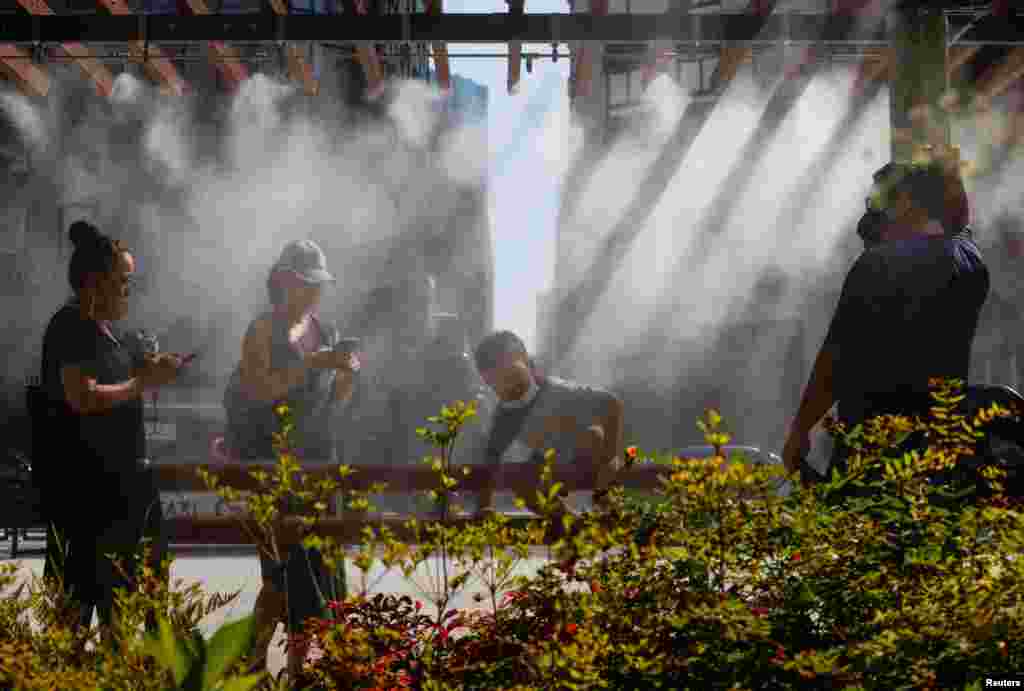 People take a break under a cooling mist as the Japanese government issues a warning about a possible power crunch because of a heatwave in Tokyo, Japan.