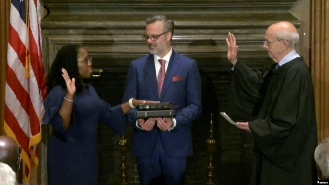 La jueza Ketanji Brown Jackson toma juramento judicial de su cargo a la Corte Suprema de EEUU ante el juez Stephen Breyer, a quien reemplaza debido a su retiro, mientras el esposo de Jackson, Patrick Jackson, sostiene la Biblia, el 30 de junio de 2022.