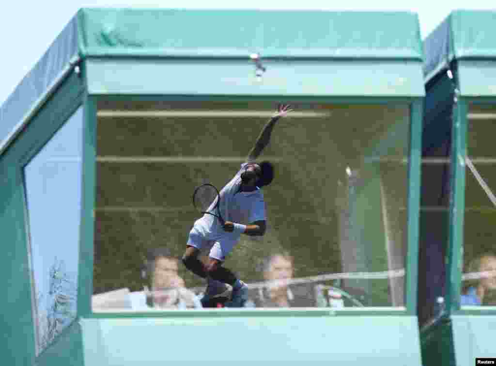 Latvia's Ernests Gulbis reflected in the window of aTV commentary position during the first round match against Britain's Jay Clarke during the Wimbledon Tennis Championships in London.
