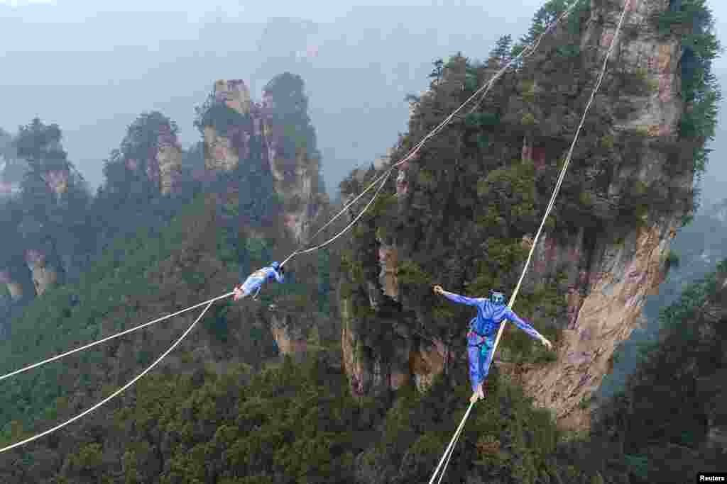 Contestants dressed as characters from the movie "Avatar" take part in a tightrope walking contest in Wulingyuan Scenic Area of Zhangjiajie, Hunan province, China.