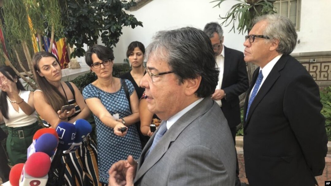 El canciller de Colombia Carlos Holmes Trujillo y el secretario general de la OEA Luis Almagro hablan con periodistas afuera de la sede de la Organización regional en Washington, el jueves 6 de septiembre de 2018. Almagro anunció que visitará Colombia para poner en funciones al grupo de trabajo que evaluará la crisis migratoria venezolana.