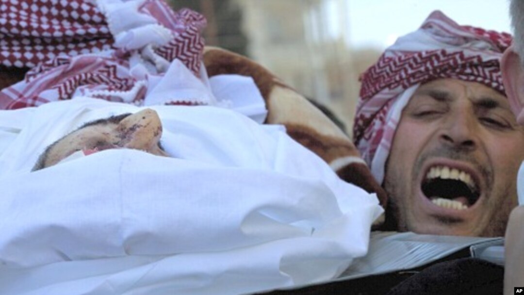 A man chants anti-government slogans while carrying the body of Abdulaziz Abu Ahmed Khrer, killed by a Syrian Army sniper, during his funeral in Idlib, north Syria, March 8, 2012