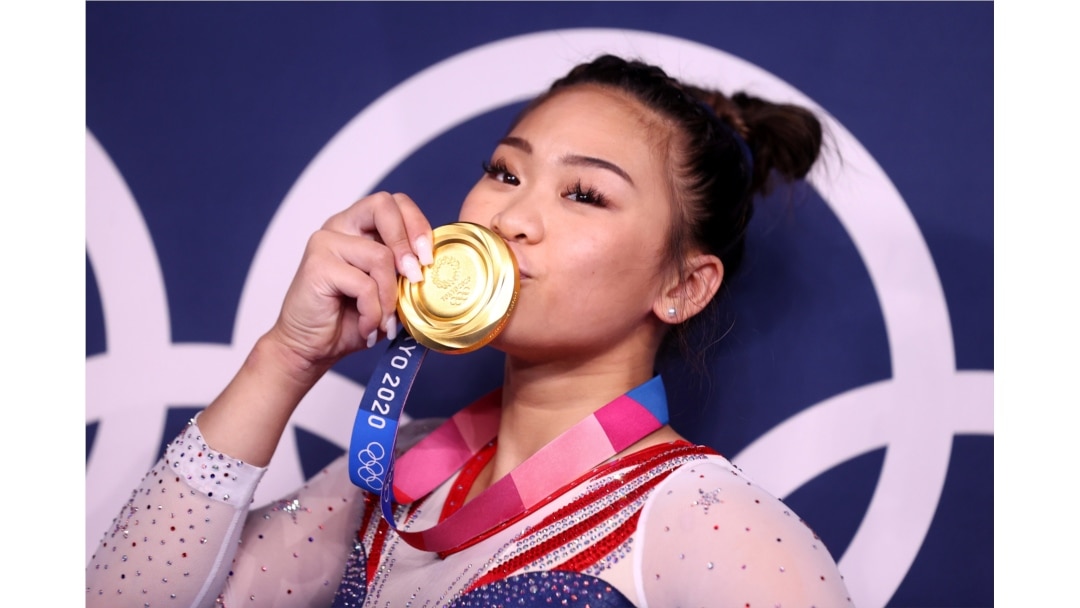 Gold medalist Sunisa Lee of the United States kisses her medal in front of the olympic rings, Ariake Gymnastics Centre, Tokyo, Japan - July 29, 2021.
