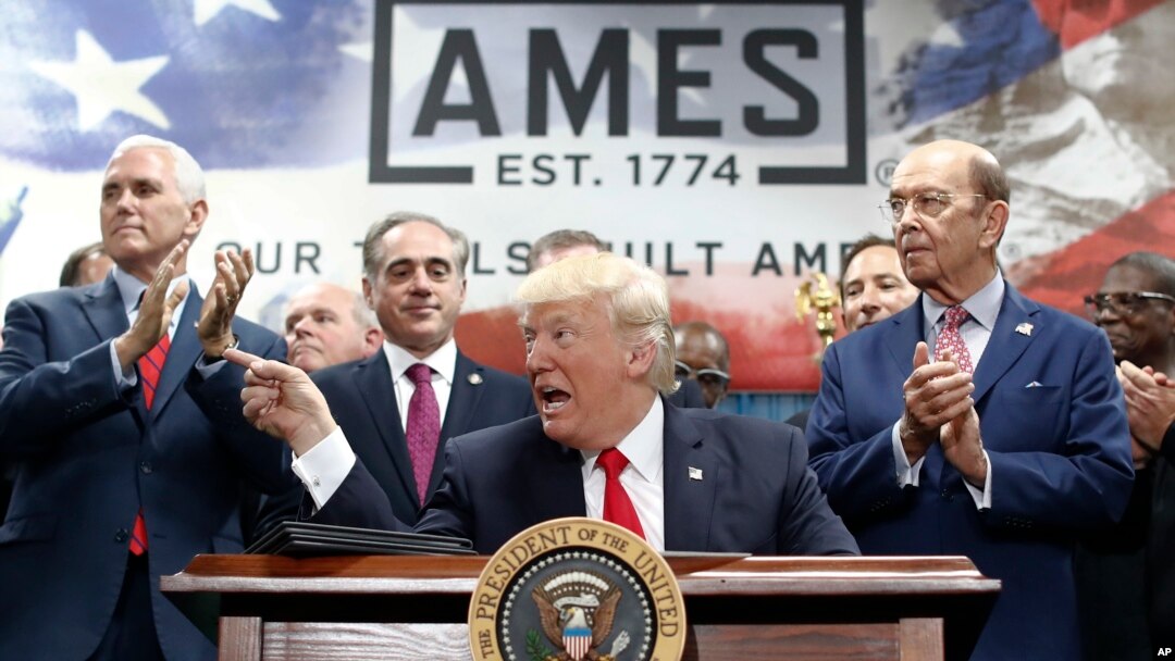President Donald Trump, joined by Vice President Mike Pence, (from left) Secretary of Veterans Affairs David Shulkin, and Wilbur Ross United States Secretary of Commerce, signs an Executive Order on the Establishment of Office of Trade and Manufacturing.