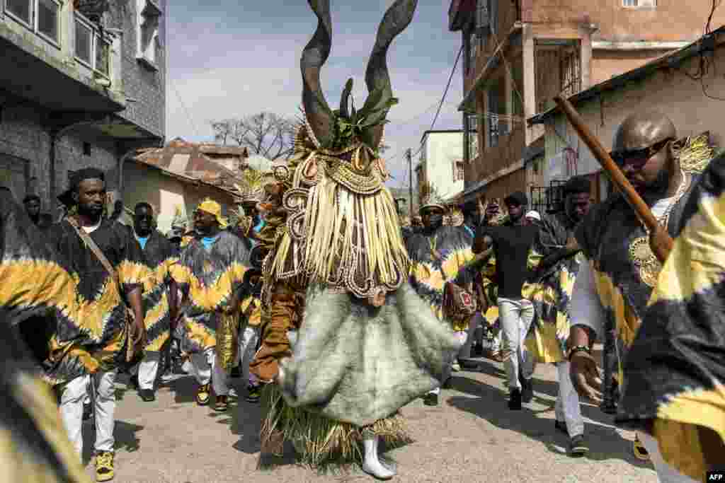 Members of the 'Ekum Baba' light up the streets of Banjul ahead of the annual hunting festival in Banjul, Gambia, Jan. 1, 2025. Rooted in tradition, this vibrant celebration marks the New Year with music, dancing, and a fierce yet friendly competition between hunting societies for the title of the best display of animal heads, masks and costumes.