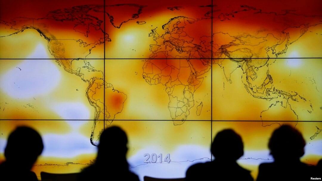 FILE - Participants are seen in silhouette as they look at a screen showing a world map with climate anomalies during the World Climate Change Conference 2015 (COP21) at Le Bourget, near Paris, France, Dec. 8, 2015. 