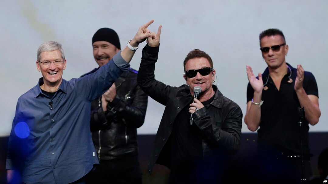 Apple CEO Tim Cook, left, with U2 members, The Edge, Bono, and Larry Mullen Jr. announce new products on Sept. 9, 2014, in Cupertino, Calif. (AP Photo/Marcio Jose Sanchez)