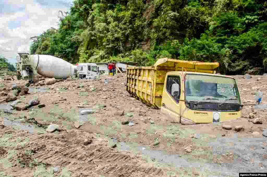 Trucks belonging to sand miners sit buried by volcanic ash after heavy rains shifted ash from the slopes of Indonesia's most active volcano, Merapi, in Magelang.