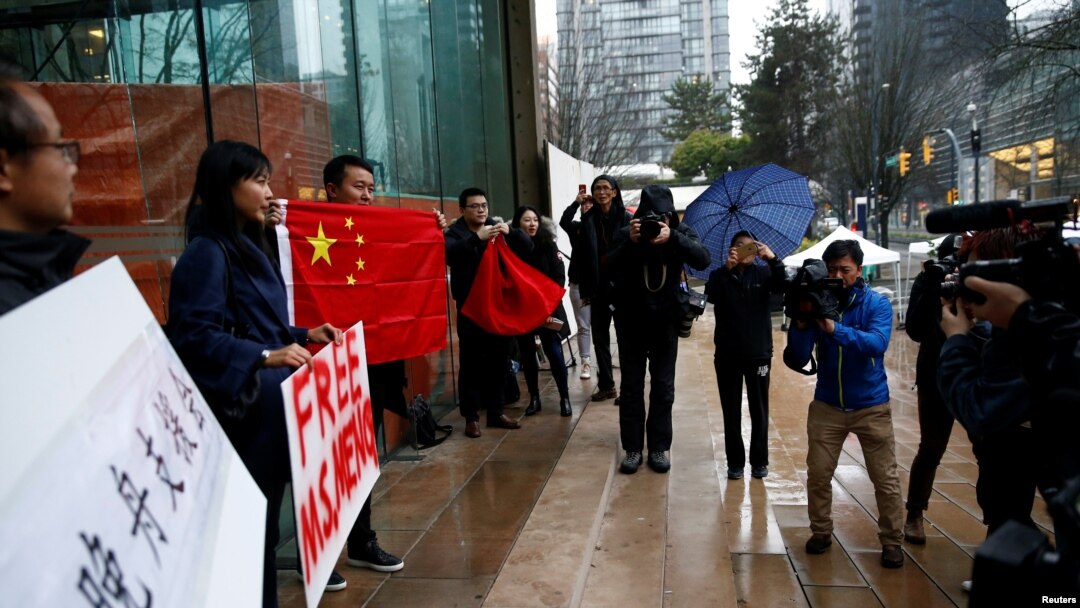 在加拿大不列顛哥倫比亞省一家正在審理孟晚舟案的法院外手舉中國國旗和標語牌的孟晚舟支持者。（2018年12月11日） 