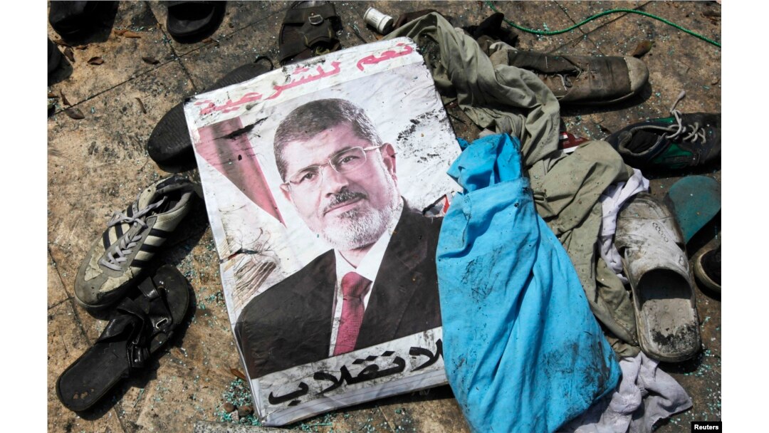 A poster of deposed Egyptian president Mohamed Morsi lies amid debris of a cleared protest camp of his supporters in Cairo Aug. 15, 2013.
