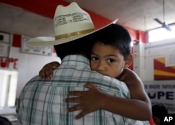 Un pequeño se aferra a su padre, un inmigrante ilegal en San Juan, Texas, Aug. 27, 2010. El niño y un hermano son ciudadanos estadounidenses por nacimiento.