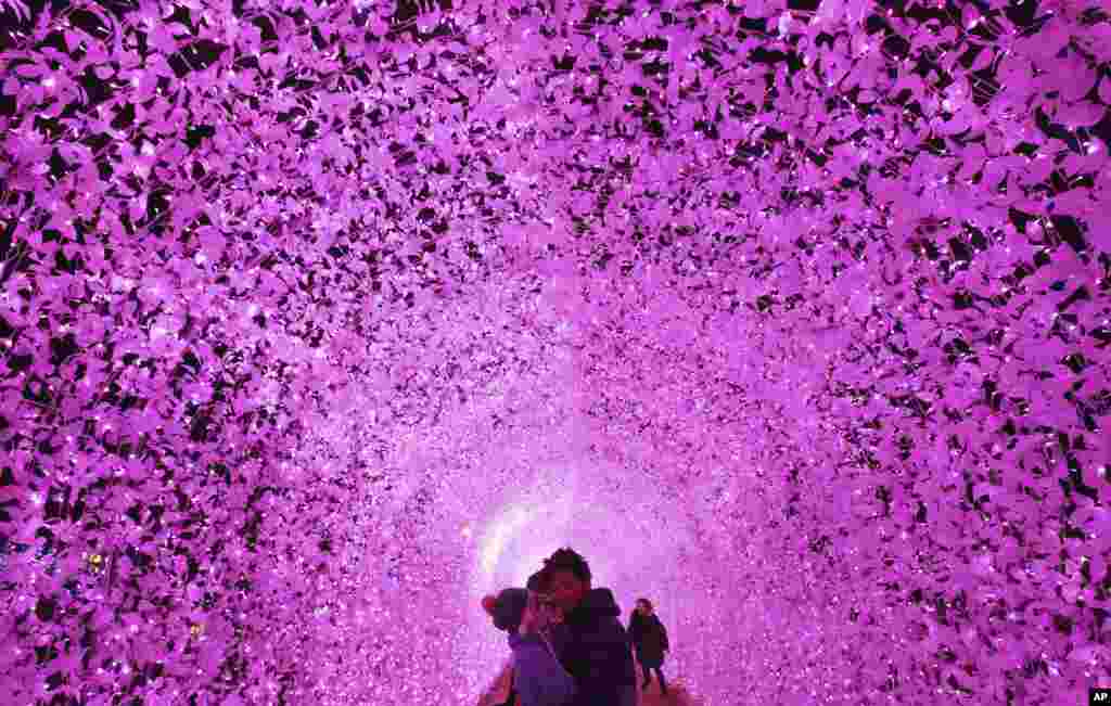 A couple poses under an illuminated tunnel to celebrate the upcoming Christmas and New Year holidays at Garden of Morning Calm in Gapyeong, South Korea. Christmas is one of the biggest holidays in South Korea.