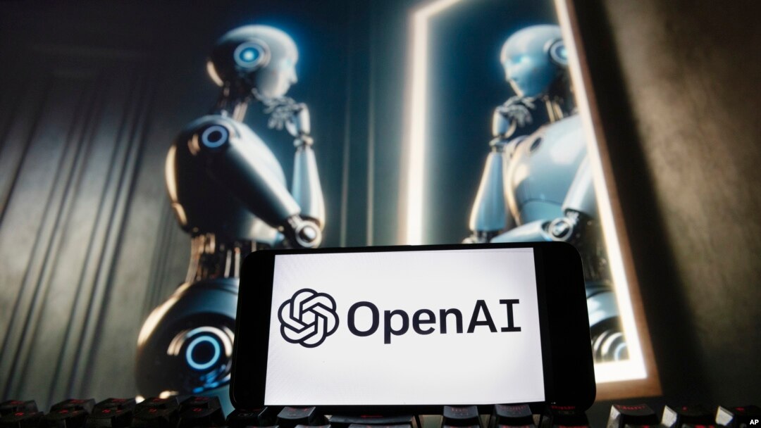 El logotipo de OpenAI se muestra en un teléfono celular con una imagen en un monitor de computadora generada por el modelo de conversión de texto a imagen Dall-E de ChatGPT, el 8 de diciembre de 2023, en Boston.