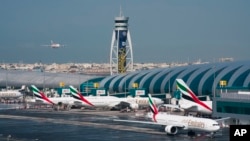 FILE - An Emirates jetliner comes in for landing at Dubai International Airport in Dubai, United Arab Emirates. 