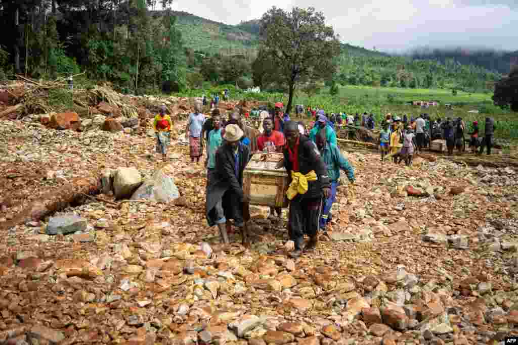 Men carry a coffin along a makeshift path on the river in Ngangu township Chimanimani, Manicaland Province, eastern Zimbabwe, after the area was hit by the cyclone Idai.
