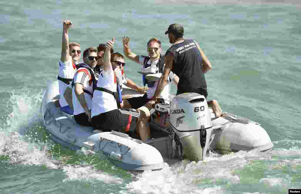 Germany's national soccer team members wave as they are transported to the sailing ship 'Pangaea' near Santo Andre village, near Porto Seguro, Brazil, June 10, 2014.