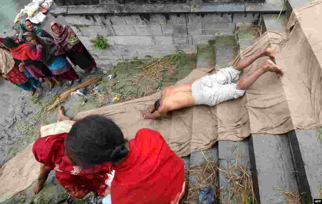 A Nepali Hindu devotee rolls on the ground after performing a bathing ritual on the last day of the month-long Swasthani Festival in the Hanumante River in Bhaktapur on the outskirts of Kathmandu.