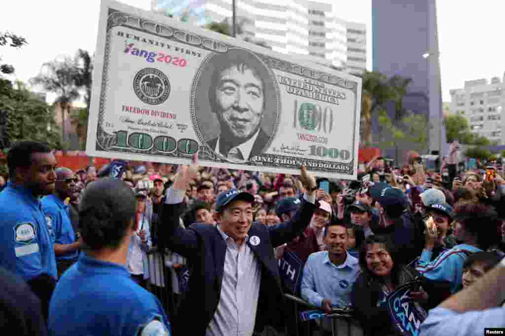 U.S. Democratic presidential candidate Andrew Yang hoists a supporter's sign after speaking at a rally in downtown Los Angeles, California, April 22, 2019.