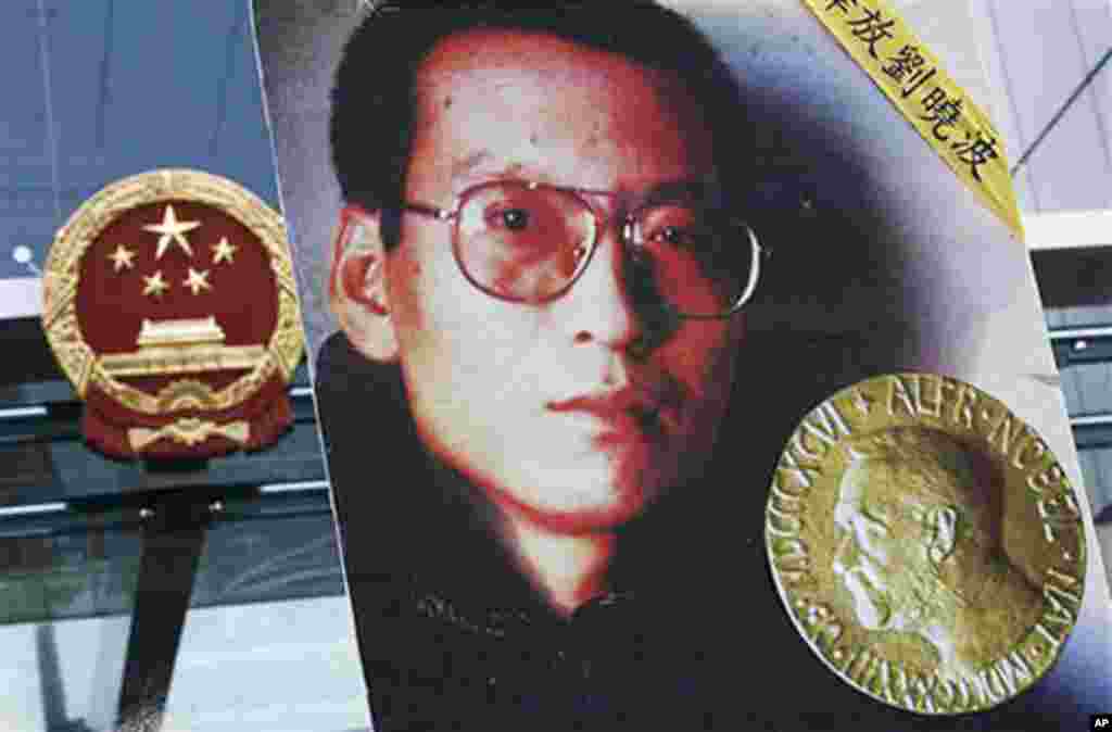 在頒獎典禮的第二天, 香港民主派市民前往中國駐香港聯絡辦公室大樓前示威,敦促中國政府釋放劉曉波,人們舉著劉曉波及其獎牌的照片(2010年10月11日)