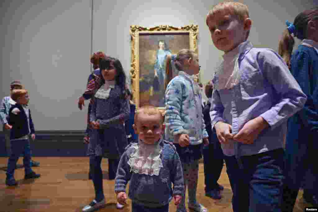 Children walk in front of Thomas Gainsborough artwork ‘The Blue Boy’ on its centenary comeback to the UK, at The National Gallery in London.