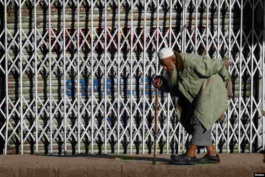 A man walks in the sunlight to warm himself on an early cold morning in Karachi, Pakistan.