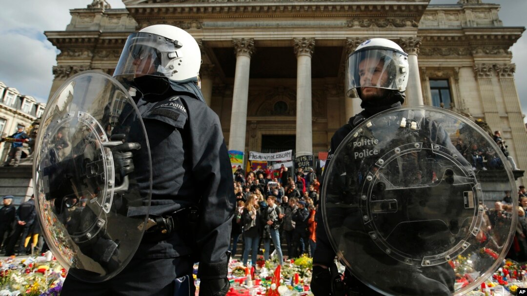 Police in riot gear protect one of the memorials to the victims of the recent Brussels attacks, as right wing demonstrators protest near the Place de la Bourse in Brussels, March, 27, 2016. 