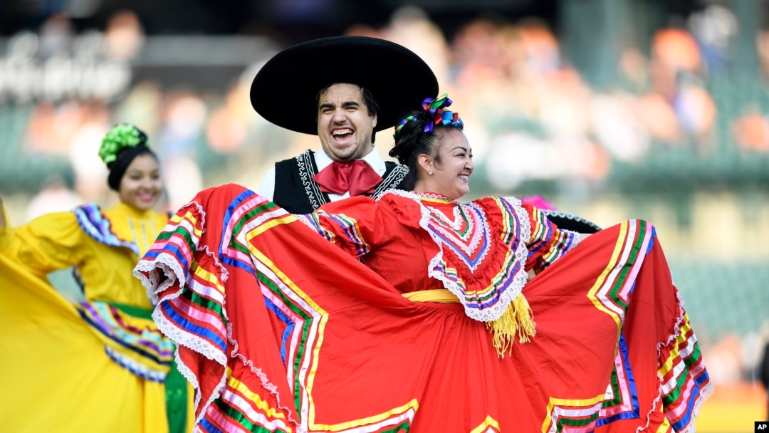 Part of a Mexican dance troupe perform on the field pregame before a baseball game between the Detroit Tigers and the Baltimore Orioles, Michigan, Sept. 14, 2024, in Detroit. The Tigers organization held many activities as part of recognizing Hispanic Heritage Month.