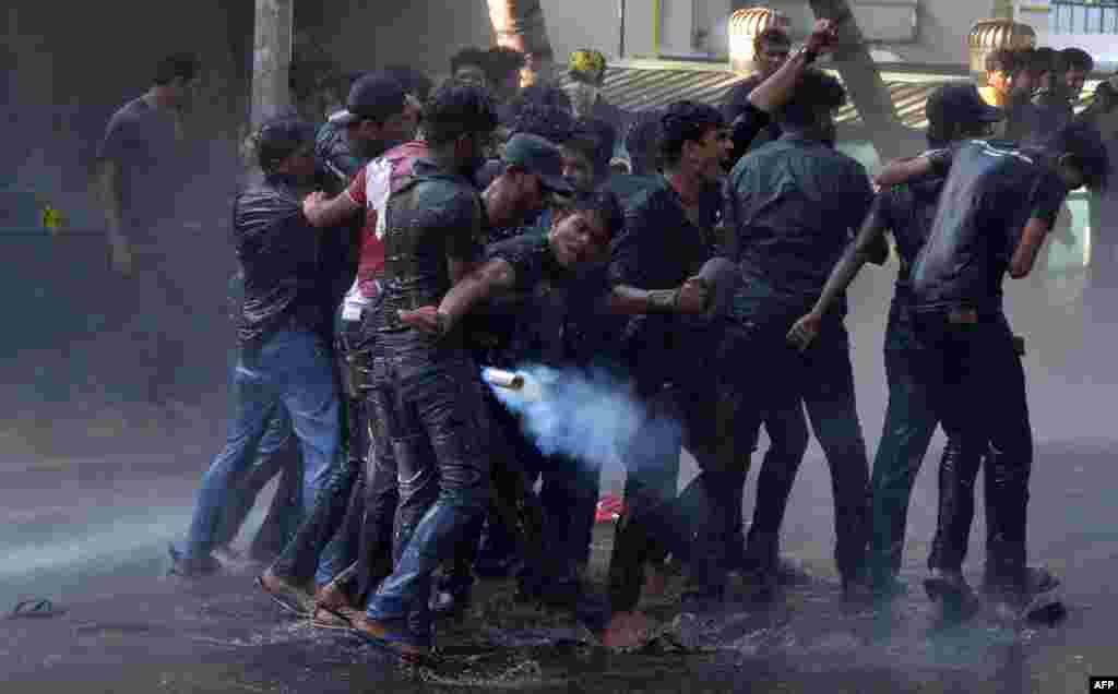 A Sri Lankan Higher National Diploma student throws a tear gas canister back towards the police during clashes in a protest march demanding better conditions at state-run universities, in Colombo.