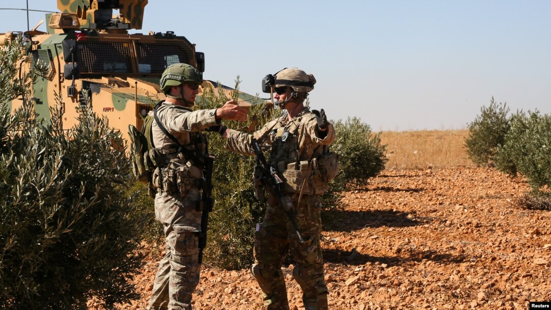 U.S. and Turkish soldiers discuss details during the first-ever combined joint patrol in Manbij, Syria, Nov. 1, 2018. (Courtesy: Arnada Jones/U.S. Army/Handout) 