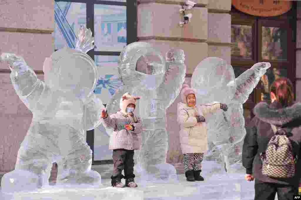 Children play with an ice sculpture of three astronauts in Harbin in China's northeastern Heilongjiang province.