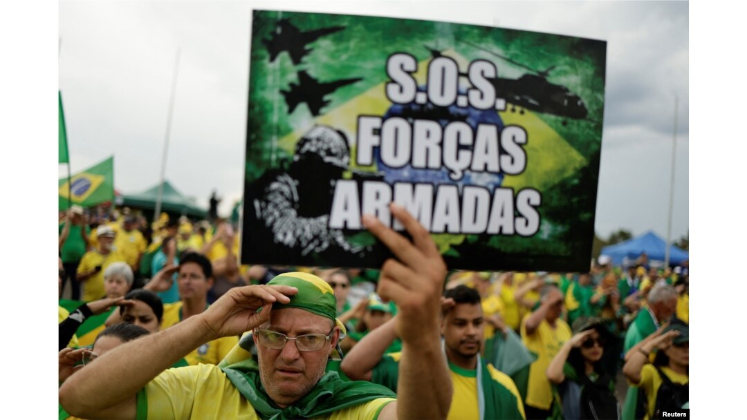 A man holds a sign that reads "SOS Armed Forces" during a protest held by supporters of Jair Bolsonaro at the Army Headquarters in Brasilia, Brazil, November 7, 2022.