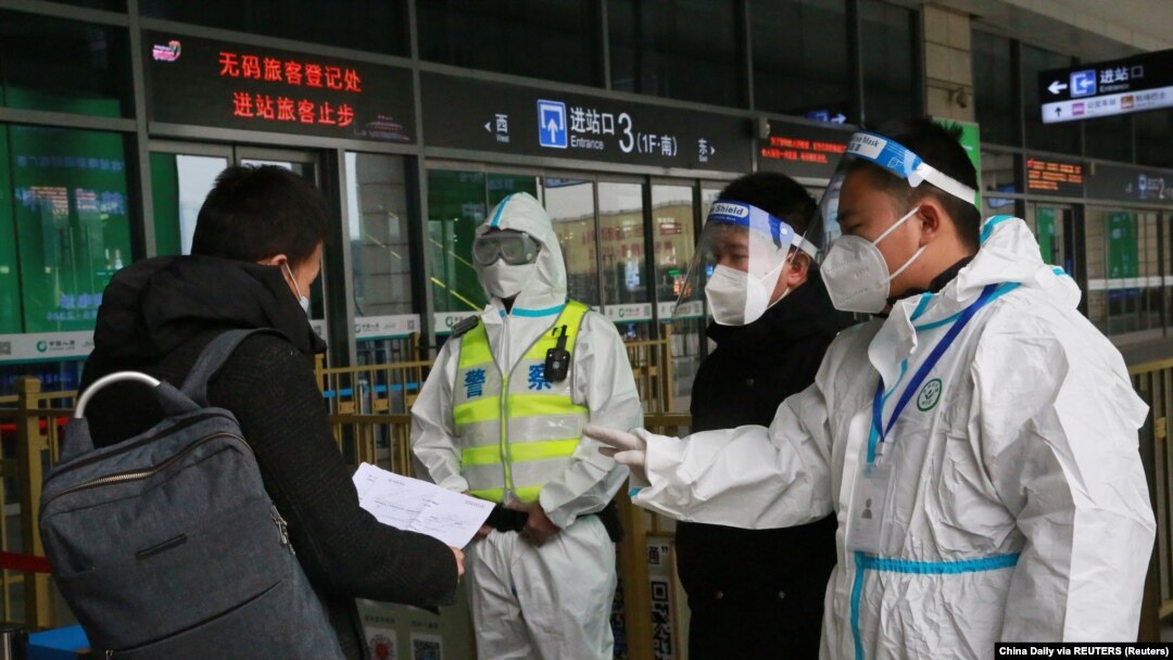 12月23日，警察和防疫人员在西安火车站检查旅客的文件。