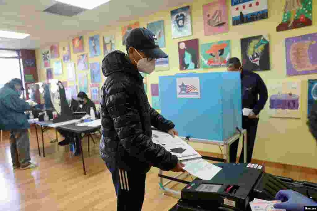First time voter Logan Walton, 18, casts his ballot at a polling station in Deja Hue Art on Election Day in Chicago, Illinois, Nov. 3, 2020.