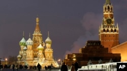 FILE - People walk in Red Square, with St. Basil Cathedral (left) the Kremlin's Spassky Tower (right rear) and Lenin Mausoleum (right) in Moscow, Dec. 10, 2009.