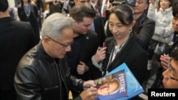 英偉達執行長黃仁勳在台灣為台北的粉絲們在雜誌封面上簽名。 （2025年1月17日）