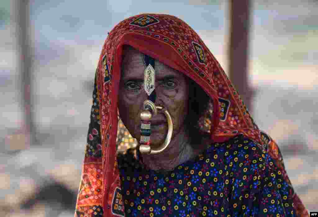 A member of a nomadic shephard community from the remote Kutch region of western Gujarat state, India, looks on at a camp where the group has relocated in search of sustenance for their livestock, in Mehsana district some 100km from Ahmedabad.