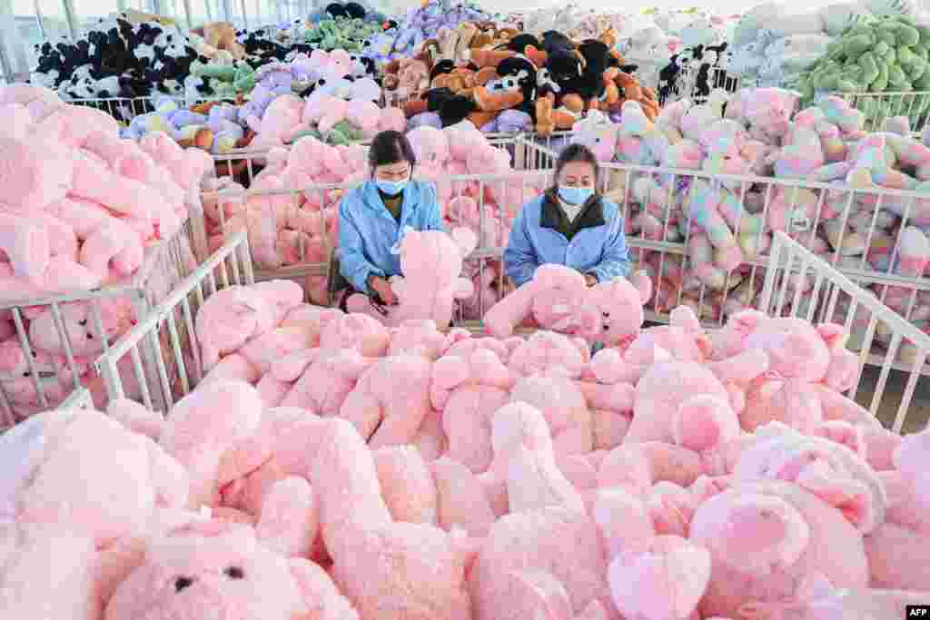 Employees work on a production line of stuffed teddy bears for export at a toy factory in Lianyungang, in eastern China's Jiangsu province.