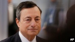 FILE - President of the European Central Bank, Mario Draghi, is on his way to a news conference after a meeting of the governing council in Frankfurt, Germany, Jan. 19, 2017.