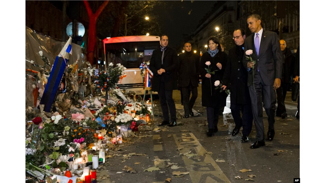 FILE - President Barack Obama, right, French President Francois Hollande, second from right, and Paris Mayor Anne Hidalgo arrive at the Bataclan, site of one of the Paris terrorists attacks, to pay their respects to the victims, Nov. 30, 2015.