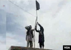 FILE - IS Khorasan group mounts a flag in tribal region of Afghanistan, Nov. 2, 2015.