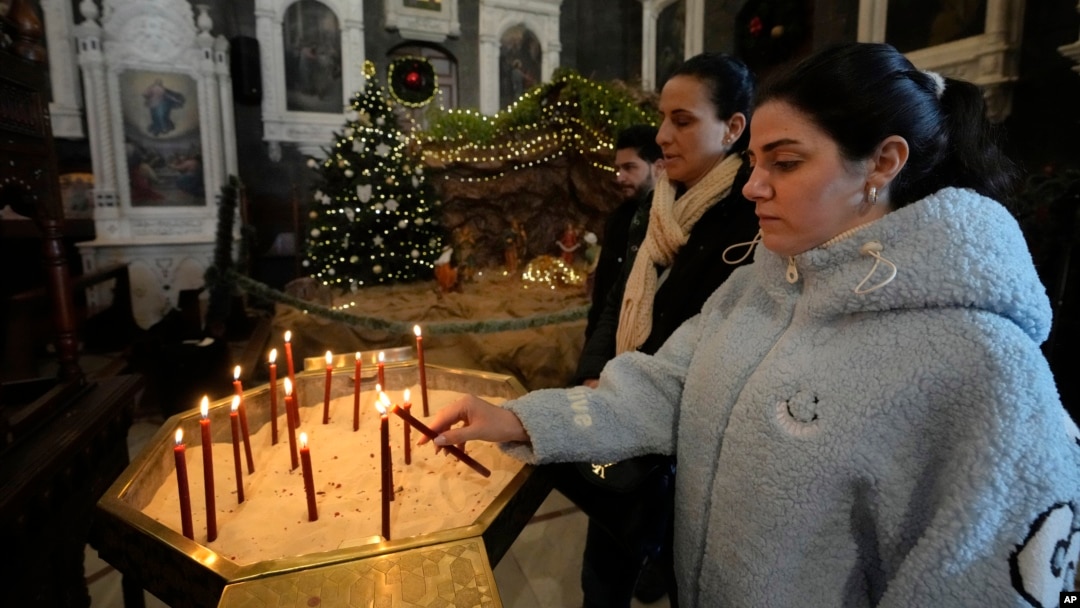 Suriyeli Hristiyan bir kadın, Esat'ın devrilmesinden sonraki ilk Pazar ayini sırasında Eski Şam'daki Mariamiya Ortodoks Kilisesi'nde mum yakıyor- 15 Aralık 2024.