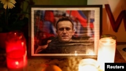 Velas encendidas mientras la gente asiste a una vigilia tras la muerte del líder de la oposición rusa Alexei Navalny, en el Trocadero, cerca de la Torre Eiffel en París, Francia, el 19 de febrero de 2024.