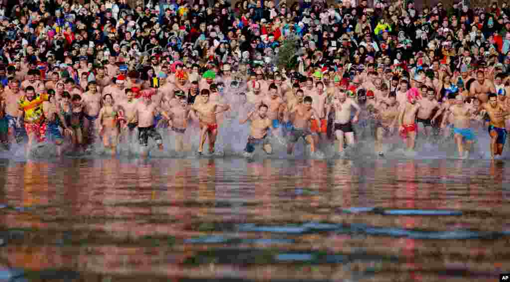 Swimmer run into the chilly water of Lake Balaton during the 8th annual New Year's swimming in Szigliget, southwest of Budapest, Hungary.