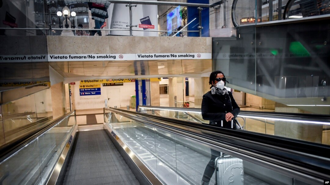 一名戴口罩的婦女在米蘭中央火車站的電梯上。（2020年3月8日）