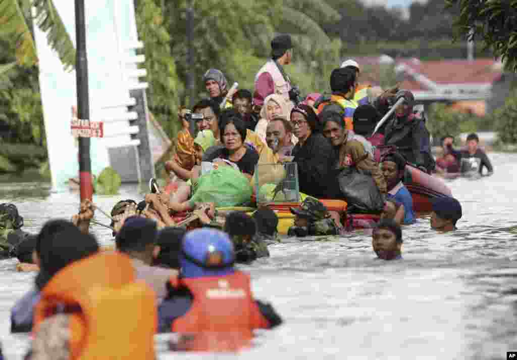 Residents evacuate their flooded homes in Makassar, South Sulawesi, Indonesia. Torrential rains and landslides displaced more than a few thousand residents in central Indonesia, officials said.
